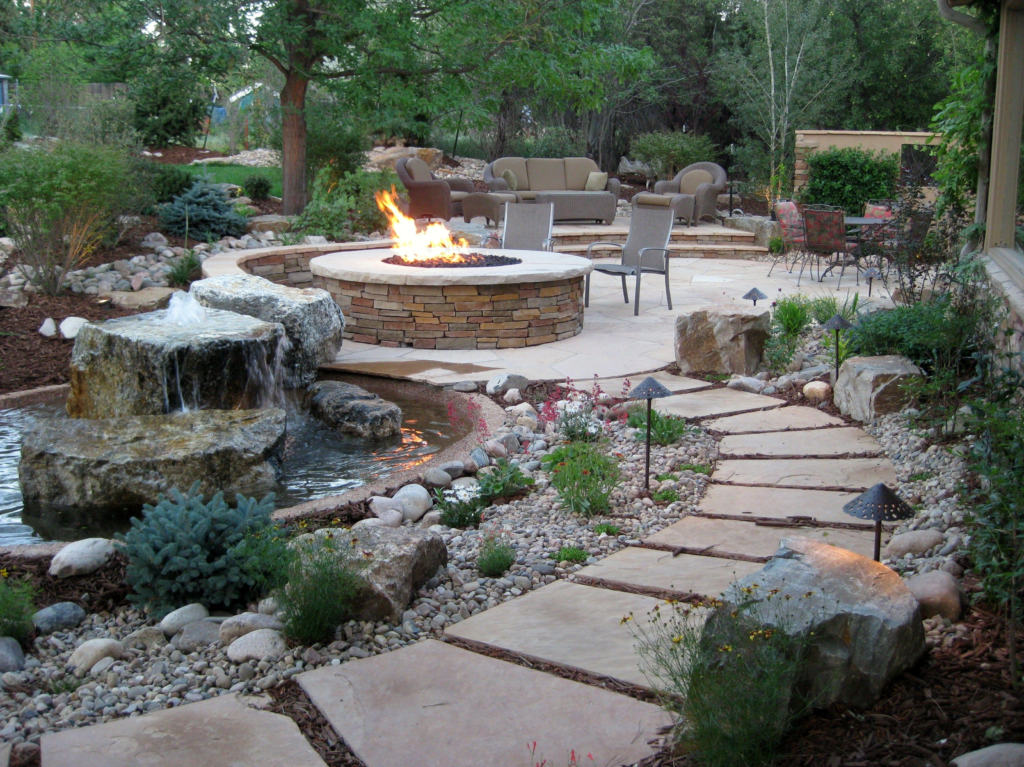 denver area yard with professional landscape features including firepit, pavers, water feature, plants, and more!
